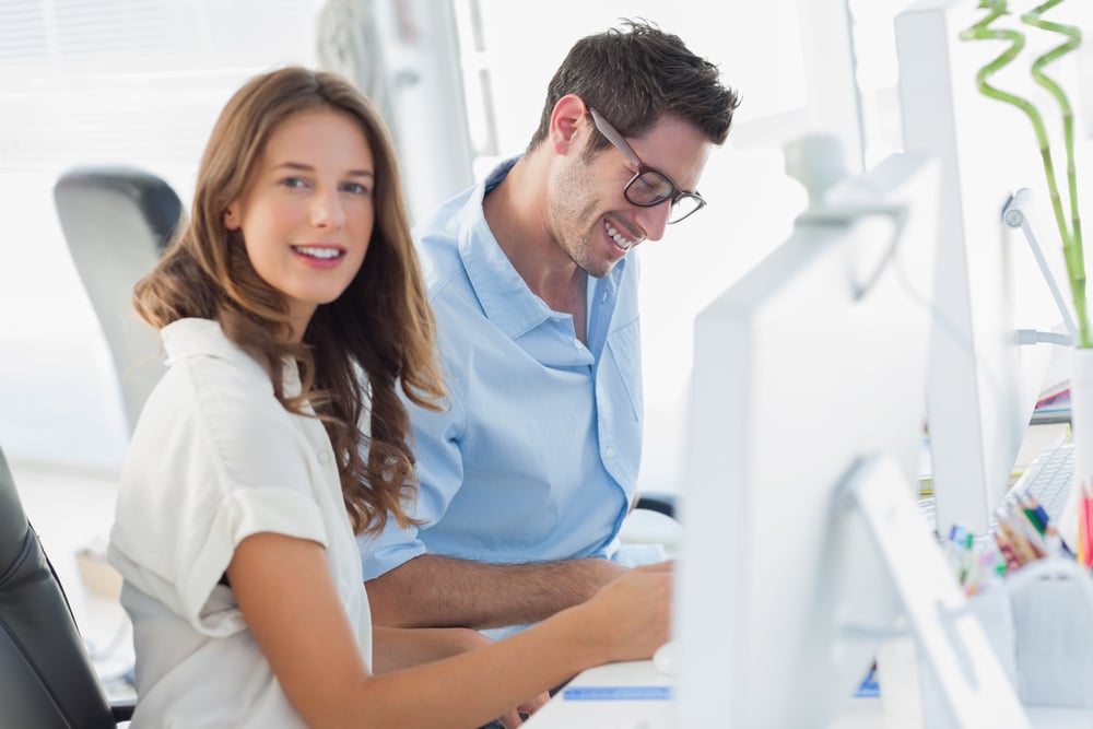 Cheerful photo editors discussing together in their modern office