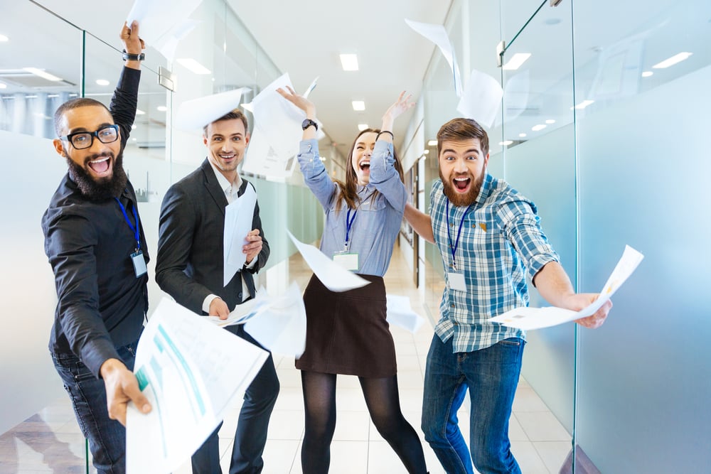 Group of joyful excited business people throwing papers and having fun in office-1